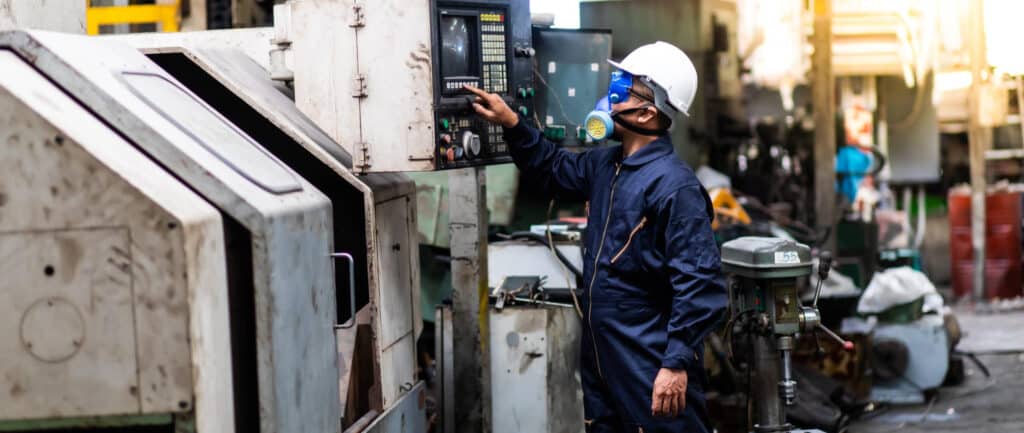 Factory worker operating industrial control panel